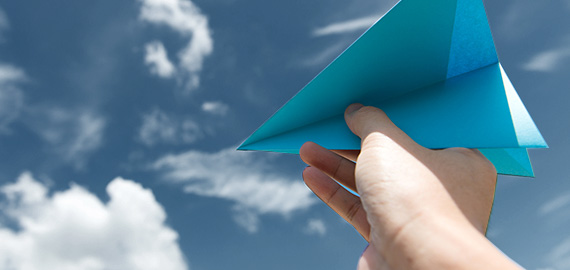 Person holding a blue paper airplane